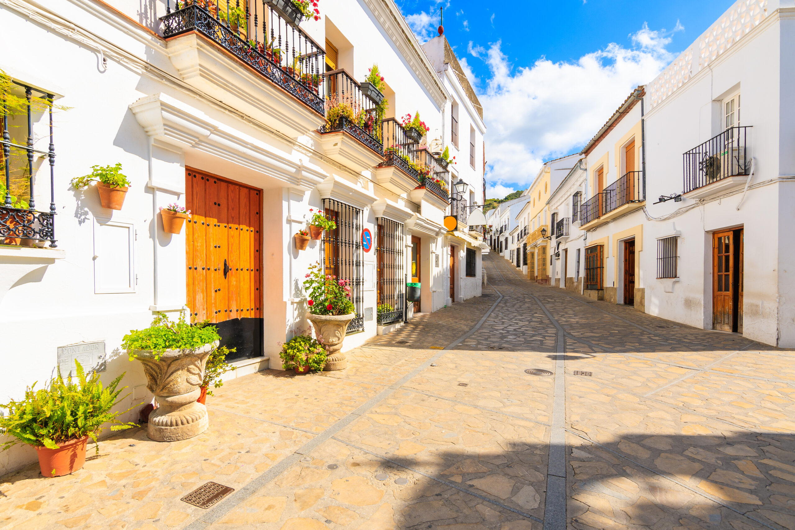 Narrow street with houses in white Andalusian village with typical Spanish architecture, Zahara de la Sierra, Spain